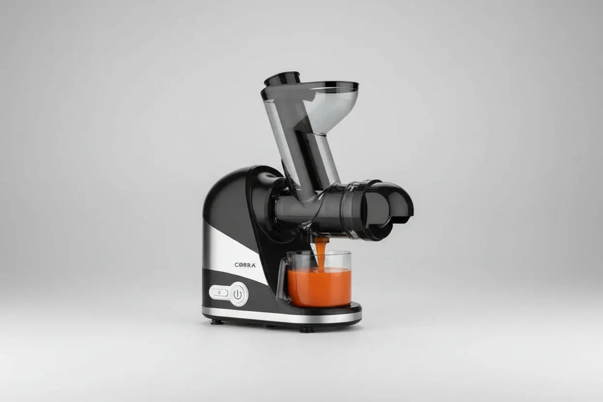 Extracteur de jus jc-90 noir et argent avec goulot transparent pressant du jus d’orange dans un verre