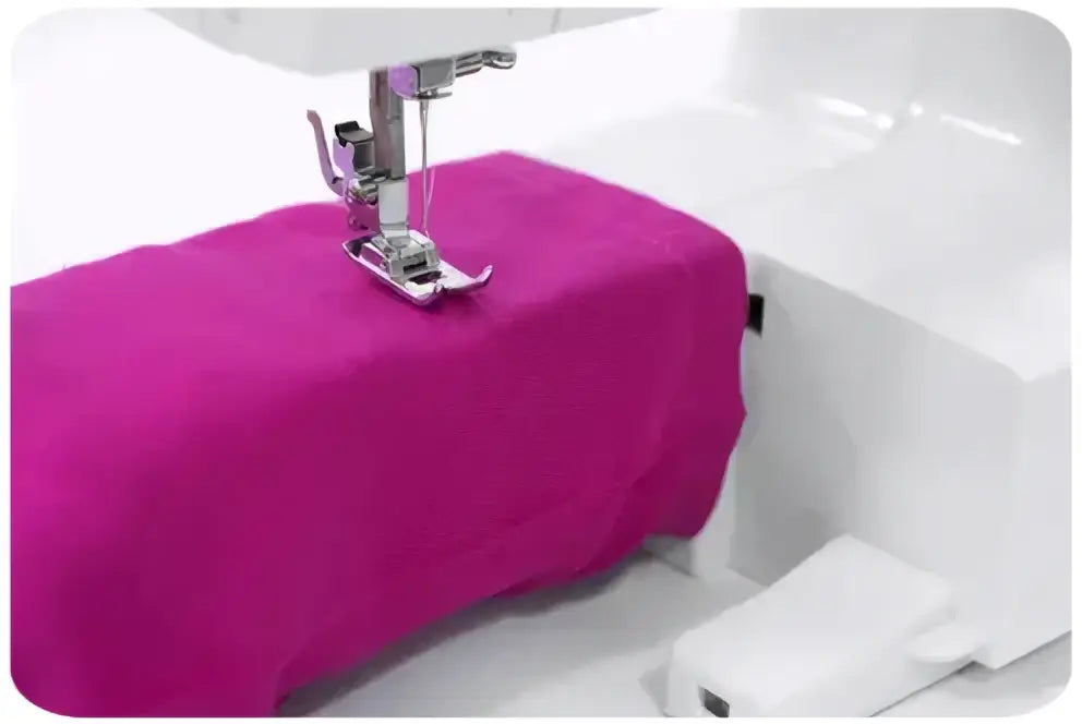 Machine à coudre 1340-V en cours d’utilisation avec un tissu vibrant magenta sous une machine blanche