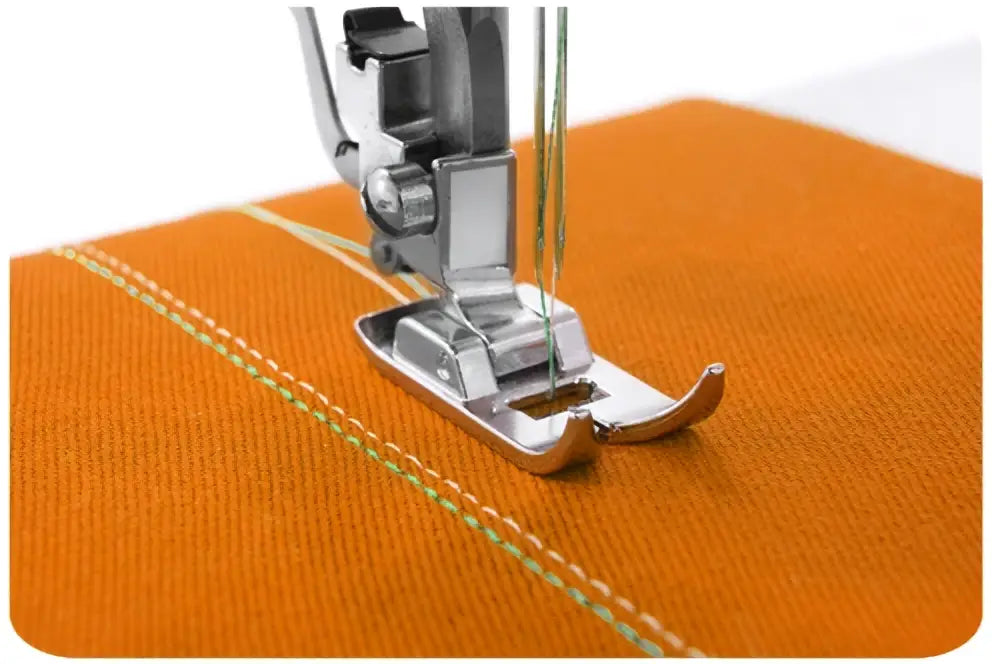 Machine a coudre 2120-v pied presseur argenté en métal positionné sur tissu orange vif en cours de couture