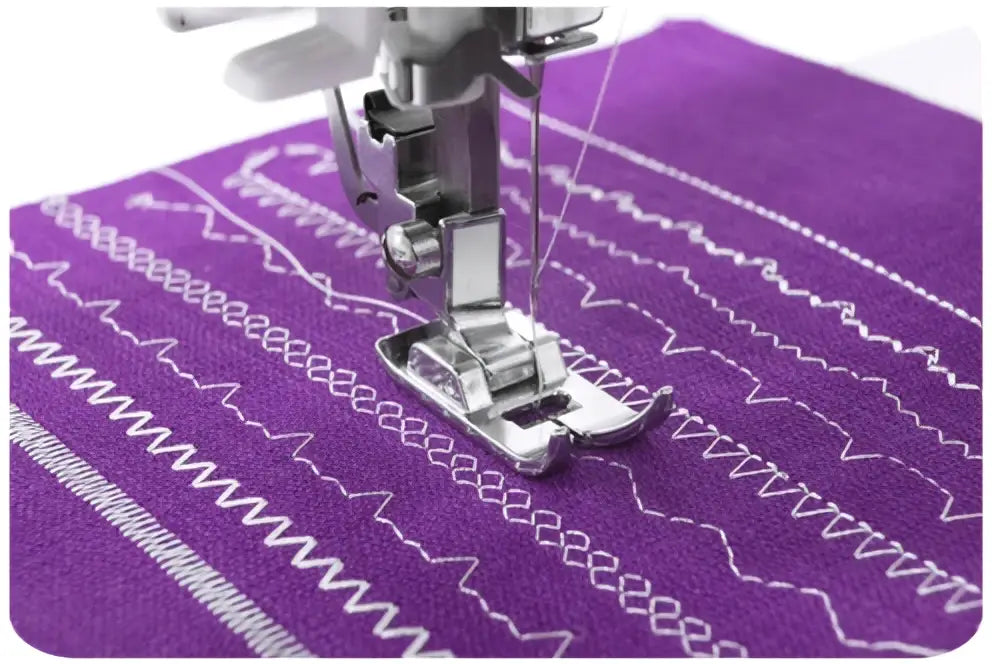 Machine à coudre 2321-v pied presseur argenté sur tissu violet avec plusieurs motifs de points blancs visibles