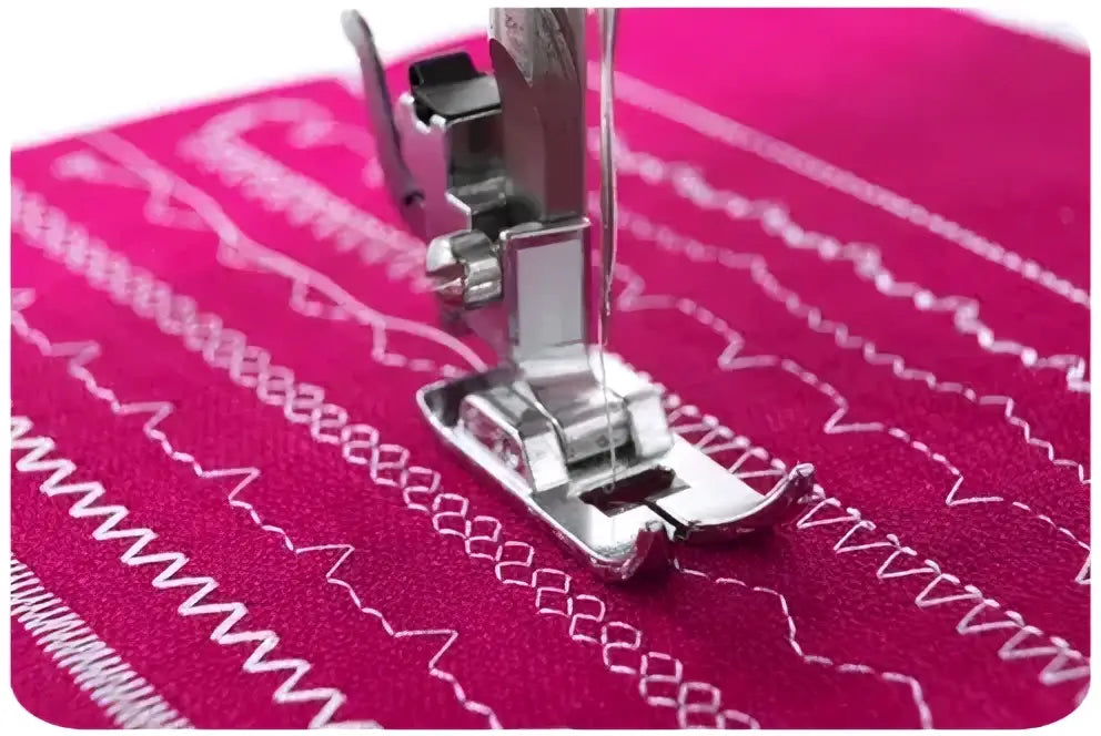 Machine a coudre 3220-v avec pied presseur métallique argenté sur tissu rose vif à motifs blancs cousus