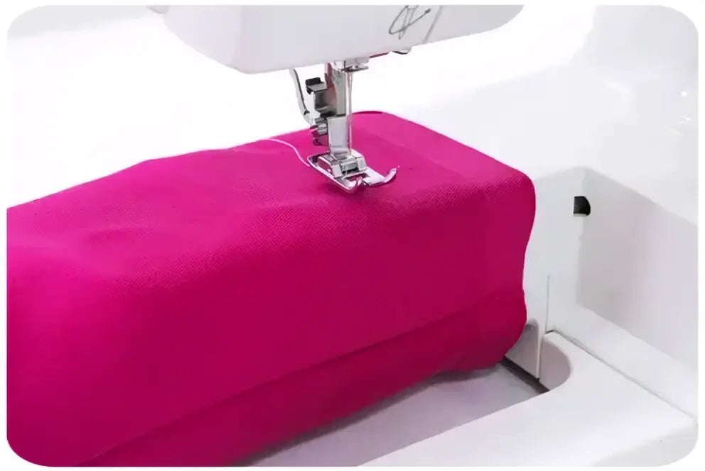 Une machine a coudre 3220-v blanche en train de coudre un tissu fuchsia vibrant sous l aiguille