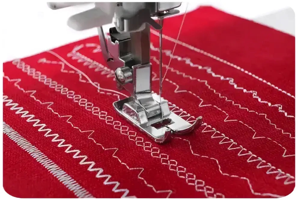 Pied presseur en métal argenté pour machine à coudre 3230-v sur tissu rouge avec motifs de couture blancs