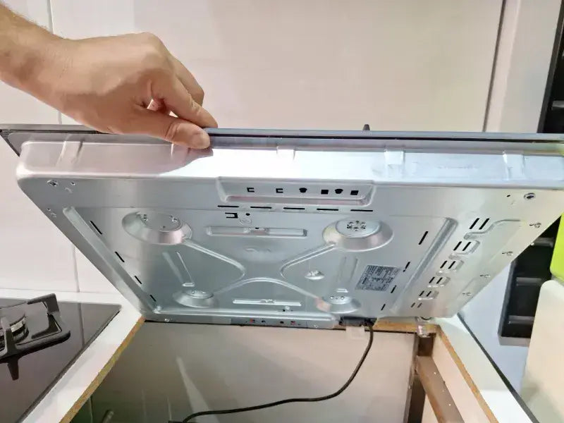 Table de cuisson 4f céramique avec hotte de cuisson en acier inoxydable argenté au design moderne et ventilation visible